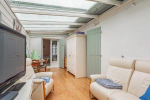 een woonkamer met witte meubels en een televisie bij Nice studio with veranda nearby the beach in La Flotte - Welkeys in La Flotte