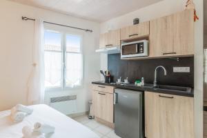 a kitchen with a stainless steel refrigerator and a microwave at Nice studio with veranda nearby the beach in La Flotte - Welkeys in La Flotte