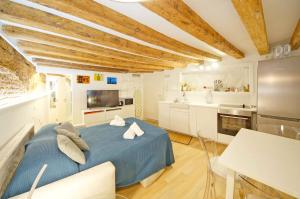 a bedroom with a blue bed and a kitchen at DolceVita Apartments N. 506 Design in Venice