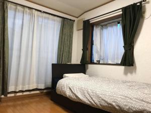 a bedroom with a bed and a mirror and curtains at Noriko's Home - Vacation STAY 13624 in Kawasaki