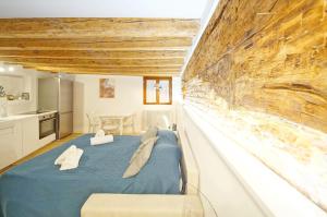 a bedroom with a blue bed and a stone wall at DolceVita Apartments N. 506 Design in Venice