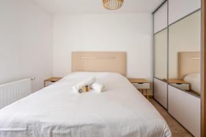 1 dormitorio con 1 cama blanca y 2 toallas en Modern flat near Montmartre at the doors of Paris in Clichy - Welkeys, en Clichy