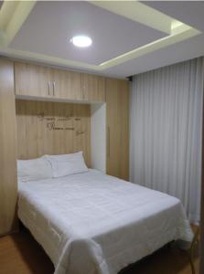 um quarto com uma grande cama branca num quarto em Apartamento mobiliado e aconchegante no Rio de Janeiro