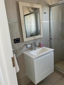 a bathroom with a sink and a mirror and a shower at Moderno Depto con Vista al Mar in Comodoro Rivadavia