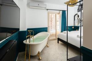 a bathroom with a tub next to a bed at The Neat Nostalgic 1BDR Studio Cairo's Downtown 20B in Cairo