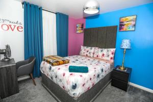 a bedroom with a bed and a chair in it at SureBillionaire Homes in Thamesmead