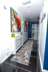 a hallway with a tile floor and a painting on the wall at SureBillionaire Homes in Thamesmead