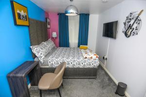 a small bedroom with a bed and a chair at SureBillionaire Homes in Thamesmead