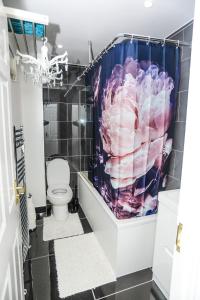 a bathroom with a toilet and a shower curtain at SureBillionaire Homes in Thamesmead