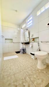 uma casa de banho com um WC branco num quarto em Chacara do Alemao em Flecheiras