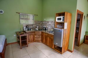 La cuisine est équipée de placards en bois, d'un four micro-ondes et d'un réfrigérateur. dans l'établissement Casa Clusia, à Monteverde Costa Rica
