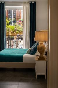 a bedroom with a bed and a window with a table at Palazzo Natoli Boutique Hotel in Palermo