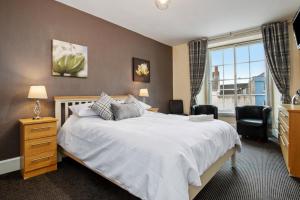 - une chambre avec un grand lit blanc et une fenêtre dans l'établissement Castle Hotel Haverfordwest, à Haverfordwest