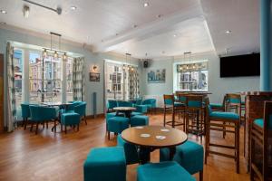 ein Restaurant mit blauen Stühlen und Tischen und eine Bar in der Unterkunft Castle Hotel Haverfordwest in Haverfordwest