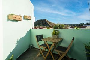 een kleine tafel en 2 stoelen op een balkon bij Casa Estábulo- Cozy Rustic Farmhouse LOFT TOURO in Estômbar