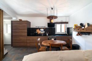 a kitchen with a table and chairs in a room at Casa Estábulo- Cozy Rustic Farmhouse LOFT TOURO in Estômbar