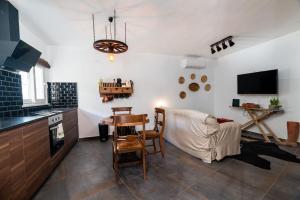 uma cozinha e sala de estar com uma mesa e um sofá em Casa Estábulo- Cozy Rustic Farmhouse LOFT TOURO em Estômbar