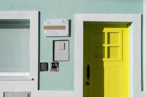 una puerta amarilla y verde en un edificio en Casa Estábulo- Cozy Rustic Farmhouse LOFT TOURO, en Estômbar