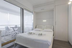 a bedroom with a white bed and a dining room at Nice flat with terrace and parking - Biarritz - Welkeys in Biarritz