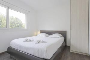 1 dormitorio blanco con 1 cama grande con sábanas blancas en Nice flat with terrace and parking - Biarritz - Welkeys en Biarritz