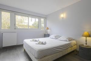 um quarto branco com uma cama com duas toalhas em Nice flat with terrace and parking - Biarritz - Welkeys em Biarritz