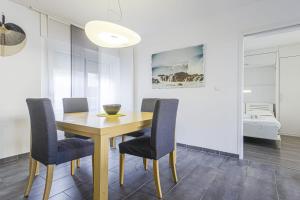 ein Esszimmer mit einem Holztisch und Stühlen in der Unterkunft Nice flat with terrace and parking - Biarritz - Welkeys in Biarritz
