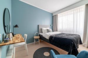 a bedroom with a bed and a table and a chair at Hotel Sparre in Porvoo +37 photos