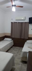Pokój z 2 łóżkami i wentylatorem sufitowym w obiekcie Pousada Bela Rainha w mieście Aparecida