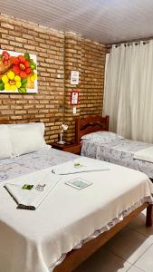 um quarto com duas camas e um quadro de flores em Chacara do Alemao em Flecheiras