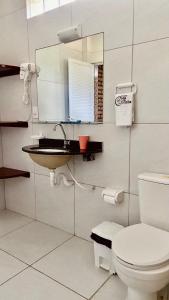 a bathroom with a toilet and a sink and a mirror at Chacara do Alemao in Flecheiras