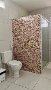 uma casa de banho com um WC e uma cabina de duche em vidro. em Chacara do Alemao em Flecheiras