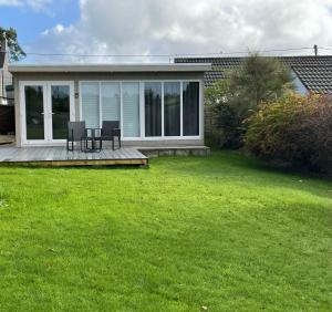 een huis met een terras met twee stoelen erop bij The Garden Room - A cosy country stay in Cornwall in Callington