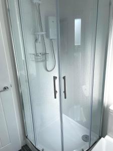 a shower with a glass door in a bathroom at The Garden Room - A cosy country stay in Cornwall in Callington