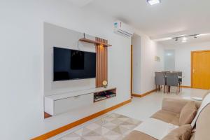 a living room with a flat screen tv on a wall at BR07 Apto 2/4 a 550m da Praia Porto da Barra in Salvador