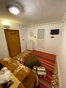 a small room with two beds and a window at Dar benelmahi in Fès