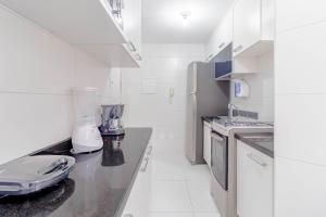 a kitchen with white appliances and a counter top at BR07 Apto 2/4 a 550m da Praia Porto da Barra in Salvador