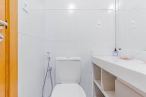 a white bathroom with a toilet and a shower at BR07 Apto 2/4 a 550m da Praia Porto da Barra in Salvador +16 photos