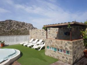 a patio with lounge chairs and a swimming pool at Alojamiento Rural el Respiro "Calma" in Benaocaz
