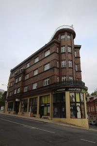 een groot bakstenen gebouw op de hoek van een straat bij Apartmán Pražská in Jablonec nad Nisou