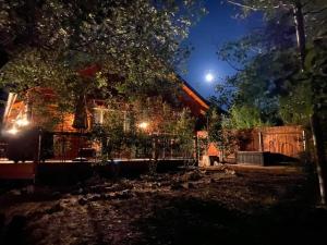 a house with a fence and a yard at night at CUSTOM SINGLE STORY CABIN WITH JACUZZI POOL TABLE & BIG GAME ROOM WITH ARCADE games in Big Bear Lake