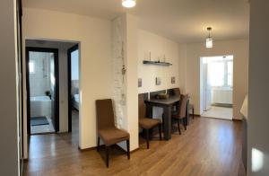 a living room with a table and chairs and a dining room at Cozy Loft in Piteşti