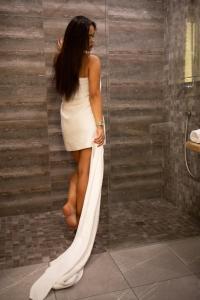 a woman in a white dress standing in a shower at Hotel DENINNA in Vinnytsya