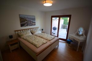 Schlafzimmer mit einem Bett, einem Spiegel und einem Fenster in der Unterkunft Apartment 12 - Geräumige Ferienwohnung im Tullnerfeld 