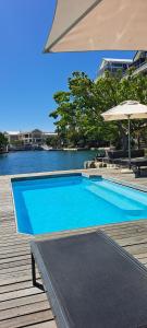 ein großer blauer Pool neben einem Wasserkörper in der Unterkunft V&A Waterfront Marina Family Apartment 101 Altmore in Kapstadt