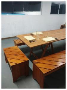 a wooden table and benches in a room at Villa sol in Cordoba