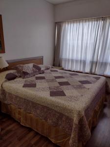 1 dormitorio con 1 cama con edredón en Departamento Corrientes Av. en Buenos Aires