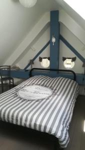 的住宿－Gîte 16 personnes(Zoo La Flèche, 24h du Mans)，一间卧室配有一张蓝色和白色条纹的床