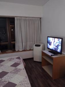 1 dormitorio con TV y ventana con radiador en Departamento Corrientes Av. en Buenos Aires