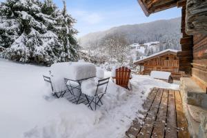 una terrazza coperta di neve accanto a una cabina di L'Échappée Belle - Welkeys a La Clusaz