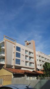 a large white building with a building at Vila do Centro Apart Hotel in Bombinhas